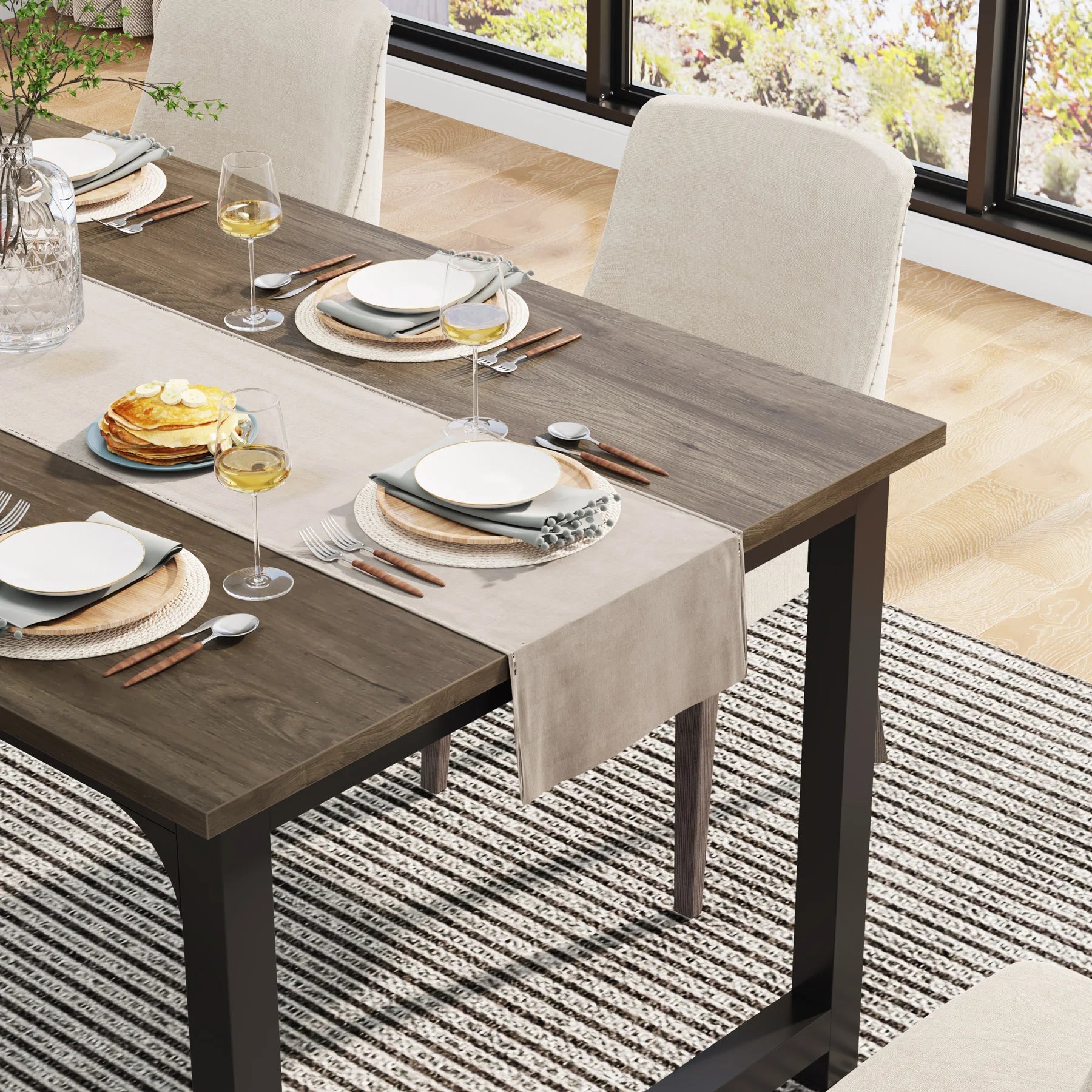 Dining table set with plates, glasses, and cutlery on a striped rug.