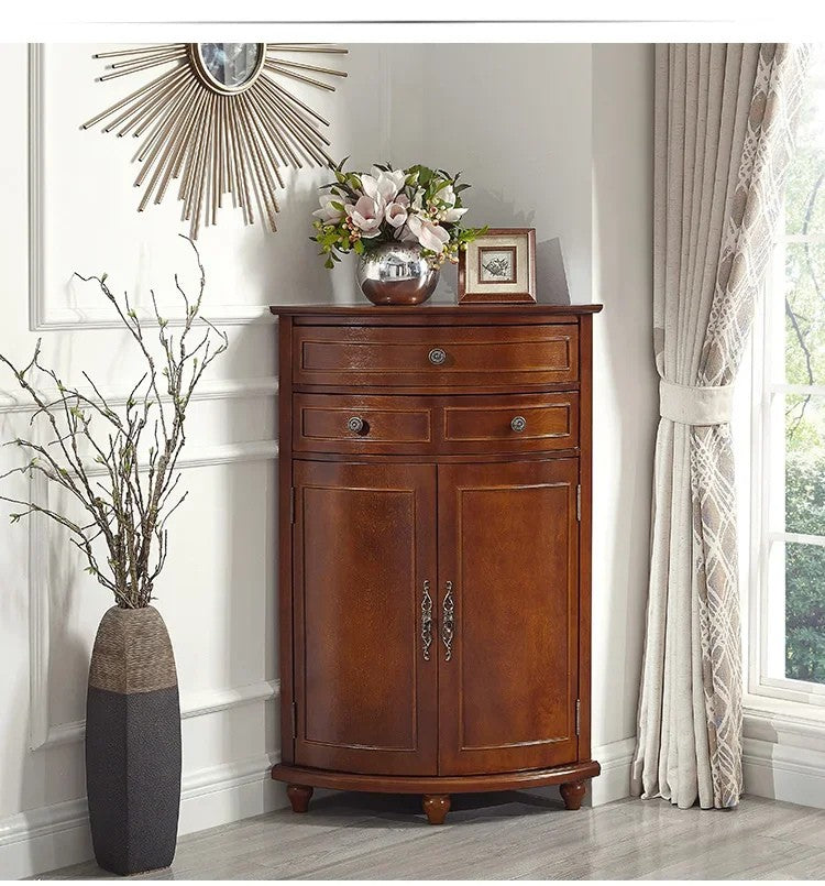 Wooden cabinet in a room with decorative elements like a vase, flowers, and mirror.