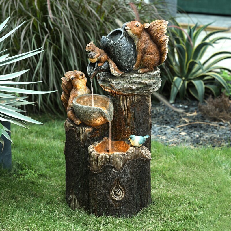 Outdoor fountain with squirrel and bird design in a garden setting