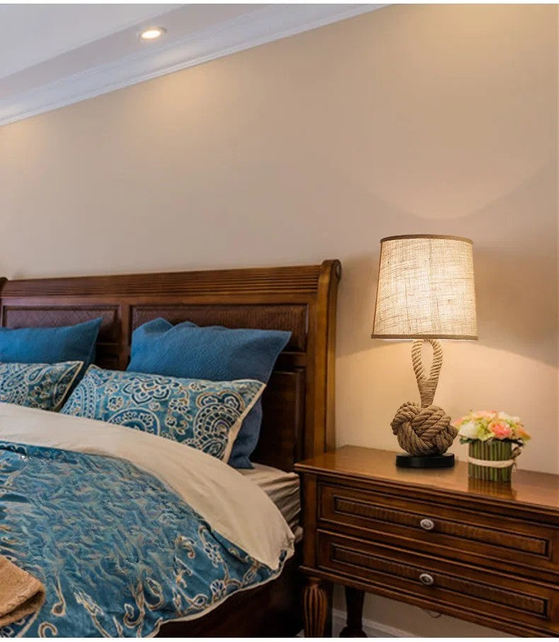 Bedroom with wooden headboard and nightstand, featuring blue bedding and a lamp.
