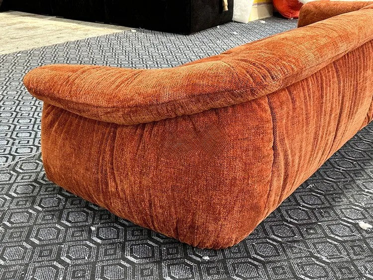 Orange textured sofa on a patterned carpet