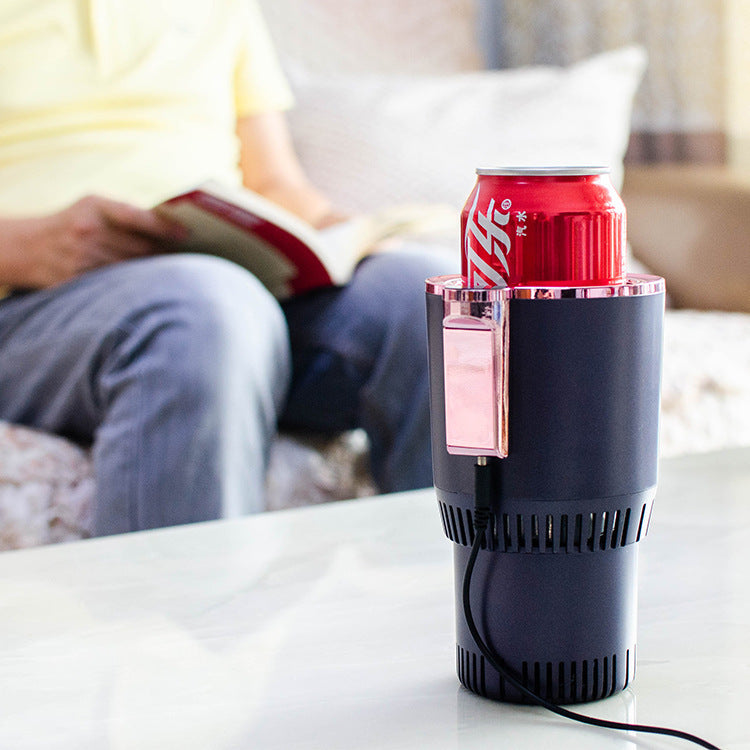 Black can cooler with a red Coca-Cola can on a table, person reading a book in the background.