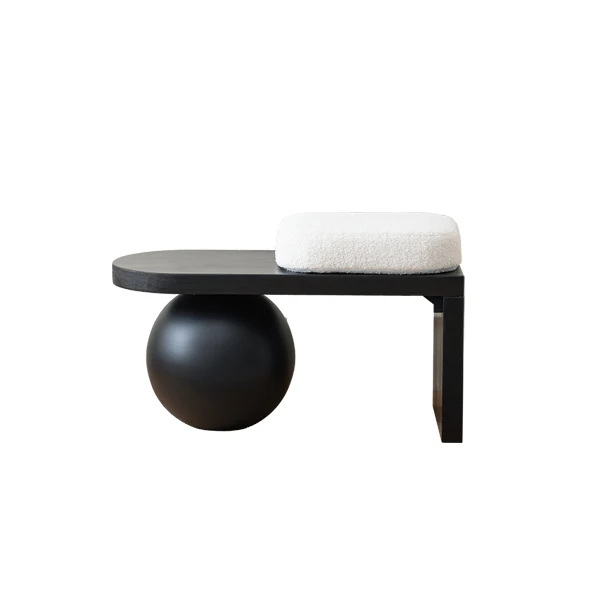 Modern black side table with spherical base and white cushion on a white background