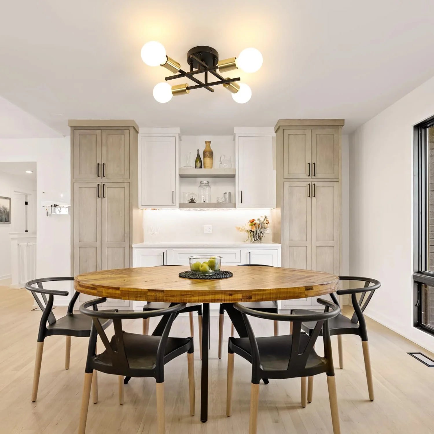 Dining area with a wooden table and black chairs in a modern kitchen.