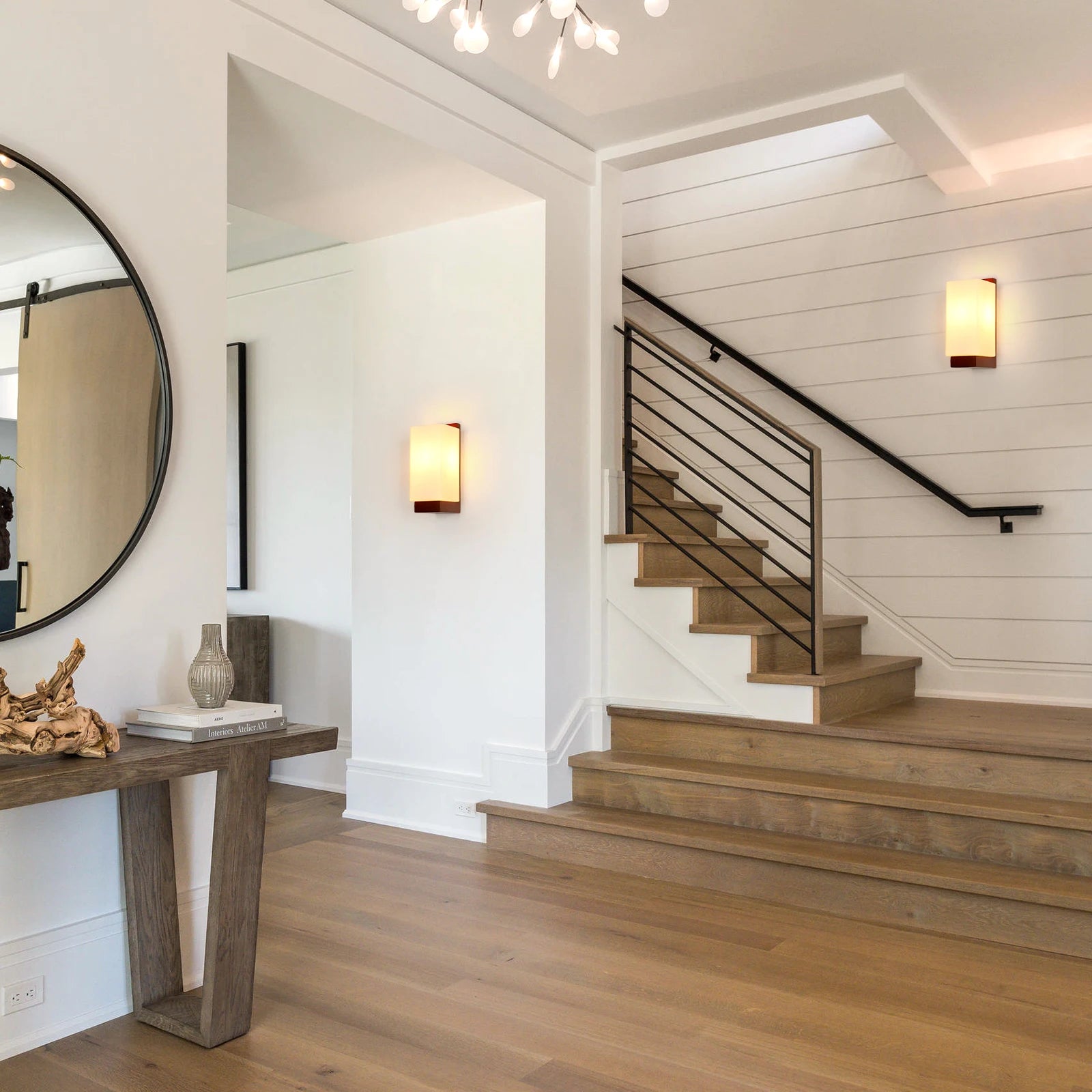 Staircase in a home with wooden flooring and wall lights.