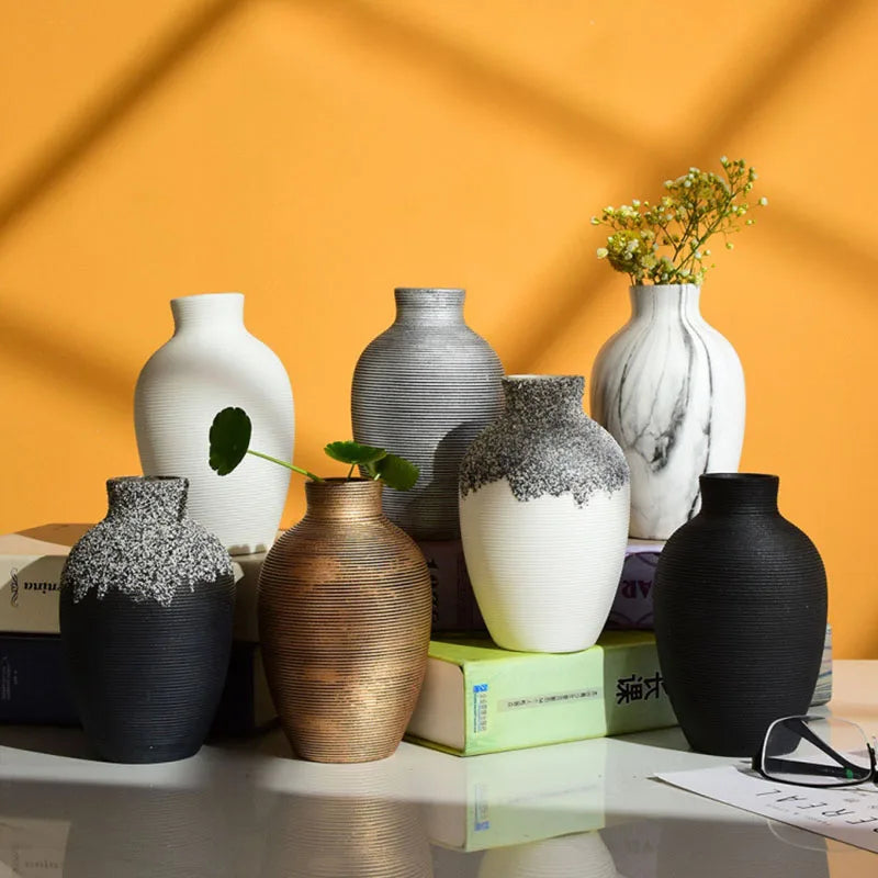 Collection of various vases on a table with a yellow wall background