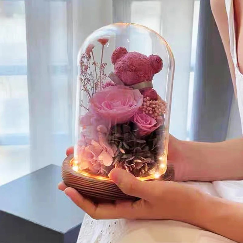 Preserved rose and moss bear in a glass dome with LED lights.