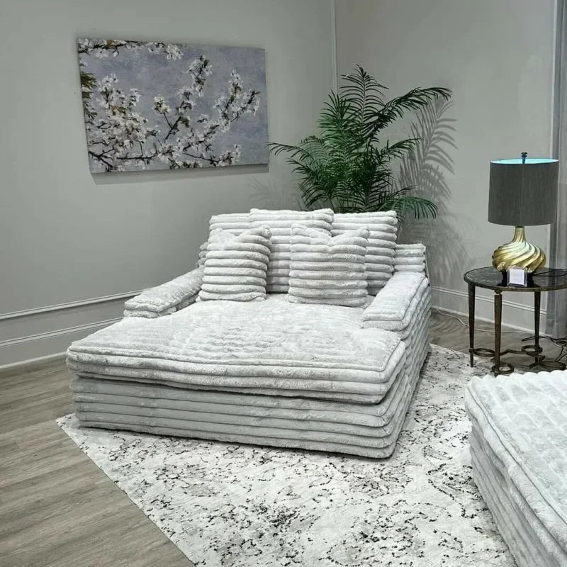 White textured sofa in a modern living room with a lamp and plant.