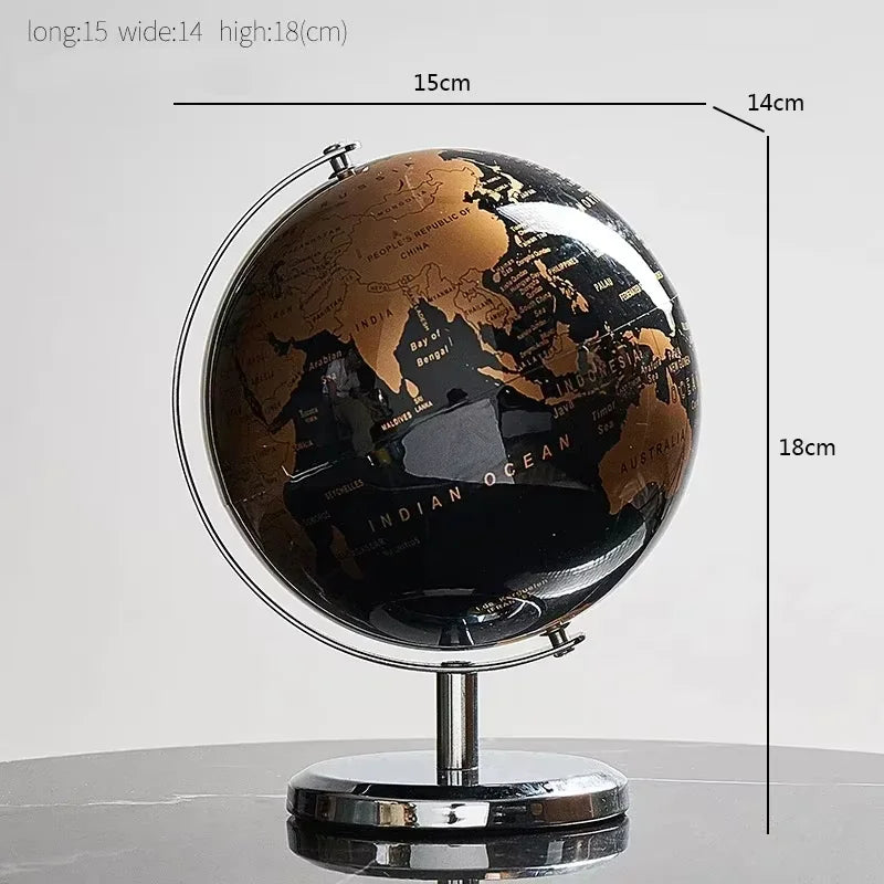 Black and gold world globe with measurements on a gray background