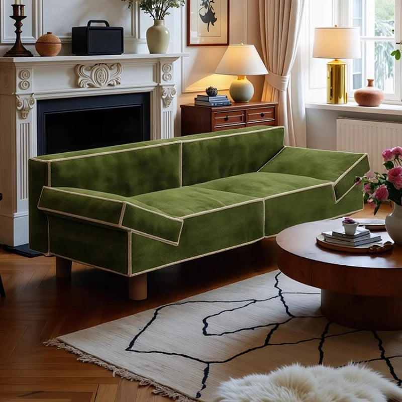 Green sofa in a living room with a fireplace and decorative items.