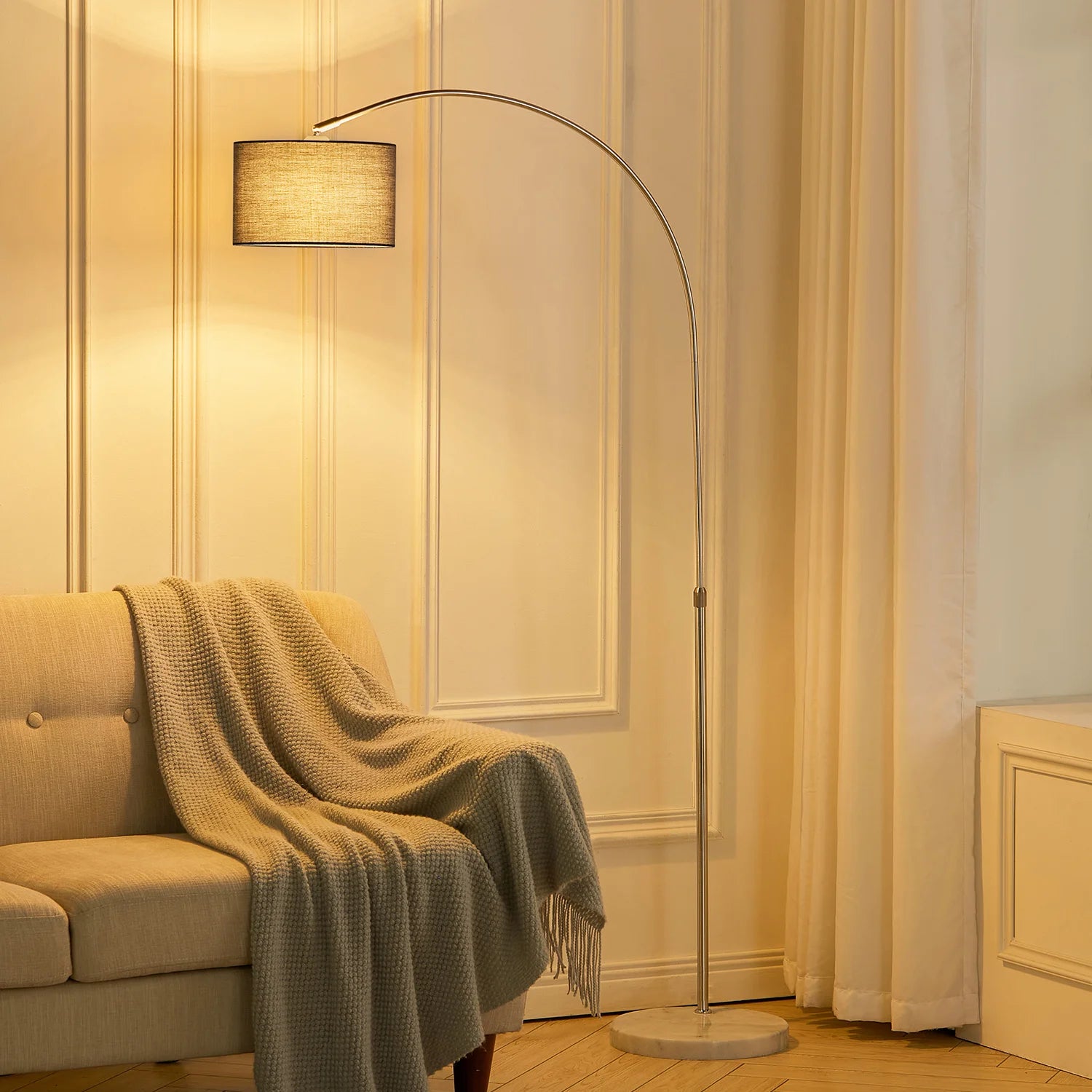 Floor lamp in a living room with a beige sofa and striped wallpaper.