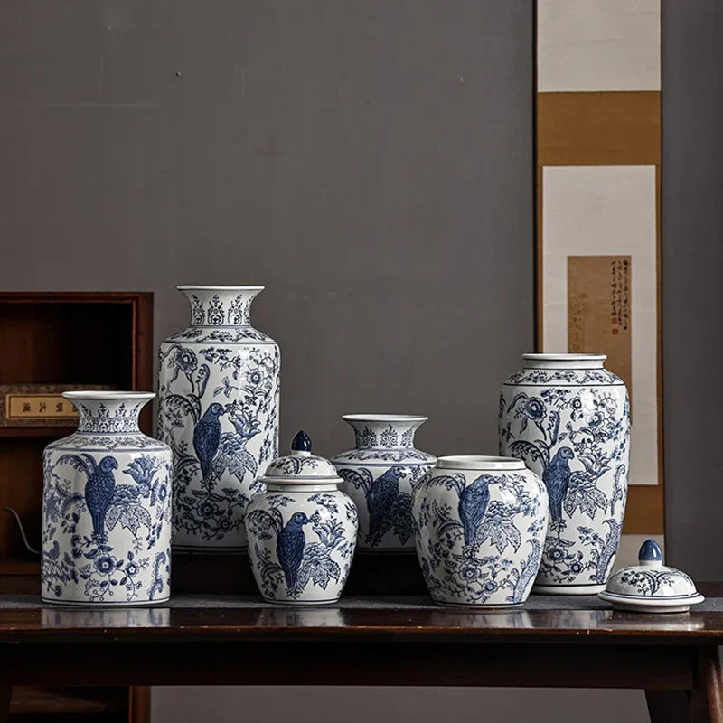 Set of blue and white ceramic vases on a wooden table against a gray wall.