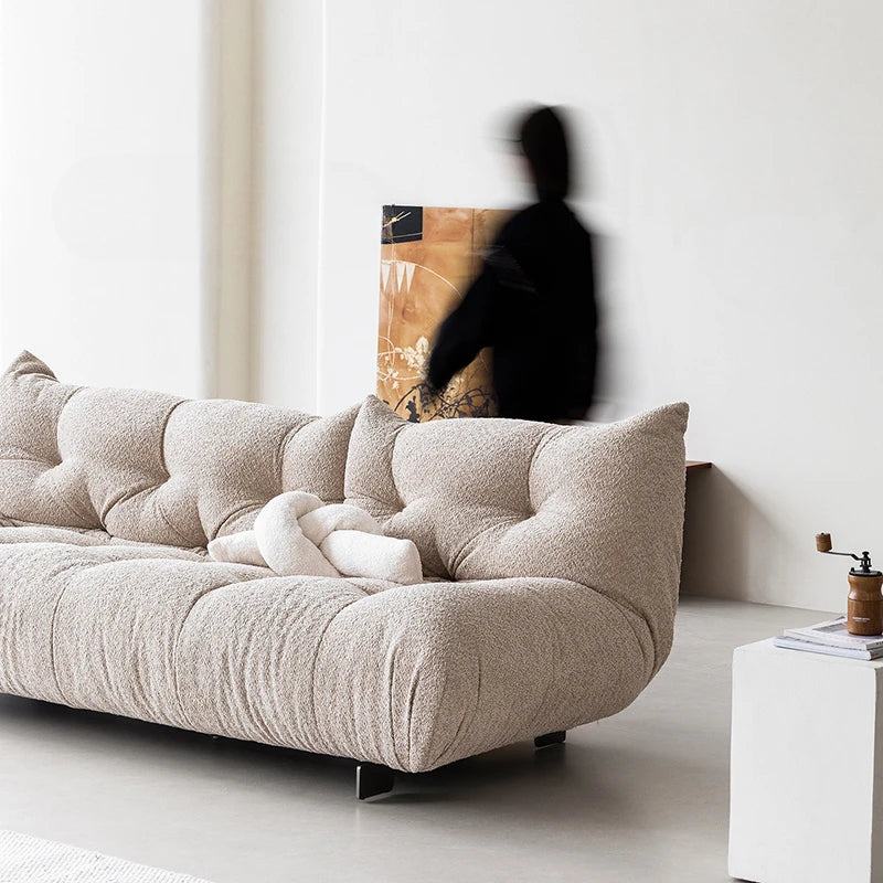 Beige sofa in a minimalistic living room with a blurred person in the background