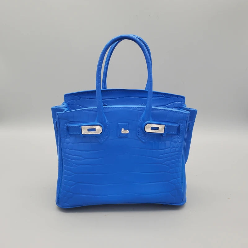 Blue handbag with silver hardware on a Gray background  Luxury vase gift idea