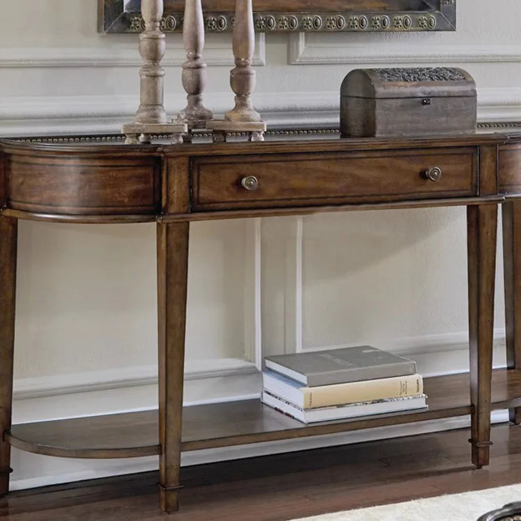 Wooden console table with decorative items against a neutral wall.