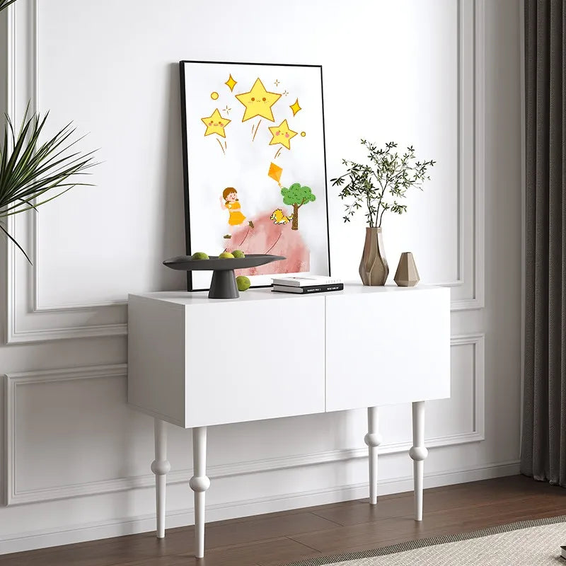 White console table with decorative items against a white wall