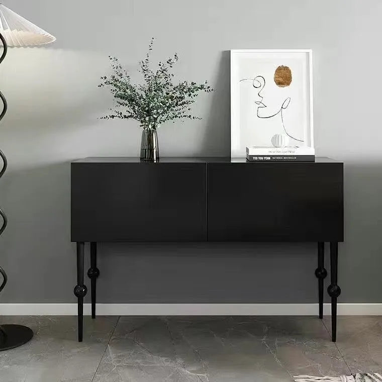 Black console table with decorative items against a gray wall