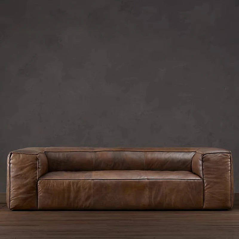 Brown leather sofa against a dark gray wall