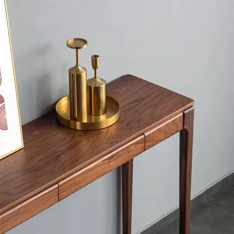 Wooden console table with gold decorative items against a light gray wall.