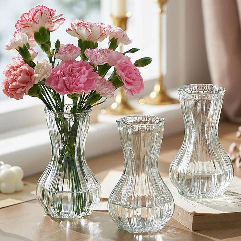 Clear glass vases with pink flowers on a table