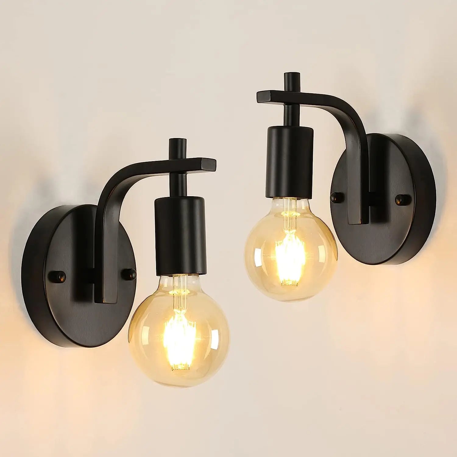 Two black wall sconces with illuminated bulbs on a light grey background