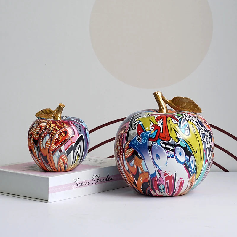 "Hand-painted resin apple figurine displayed on a shelf"