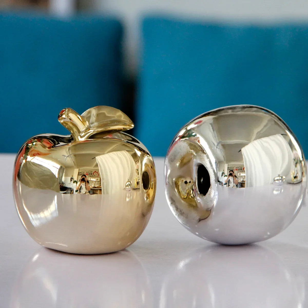 "Tabletop gold apple statue in a minimalist living room setup"