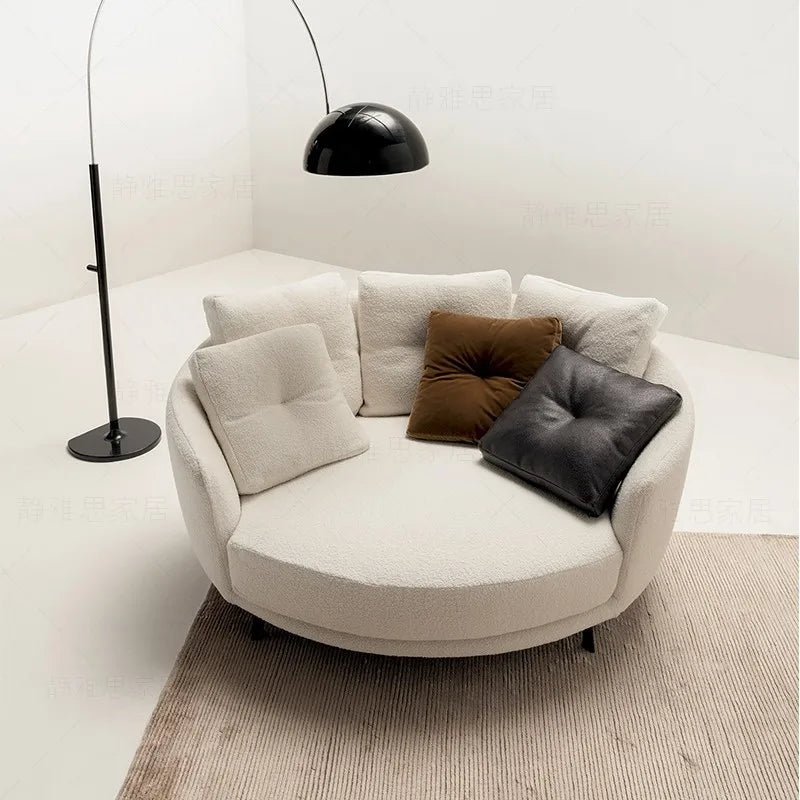 Round beige sofa with cushions in a minimalistic room
