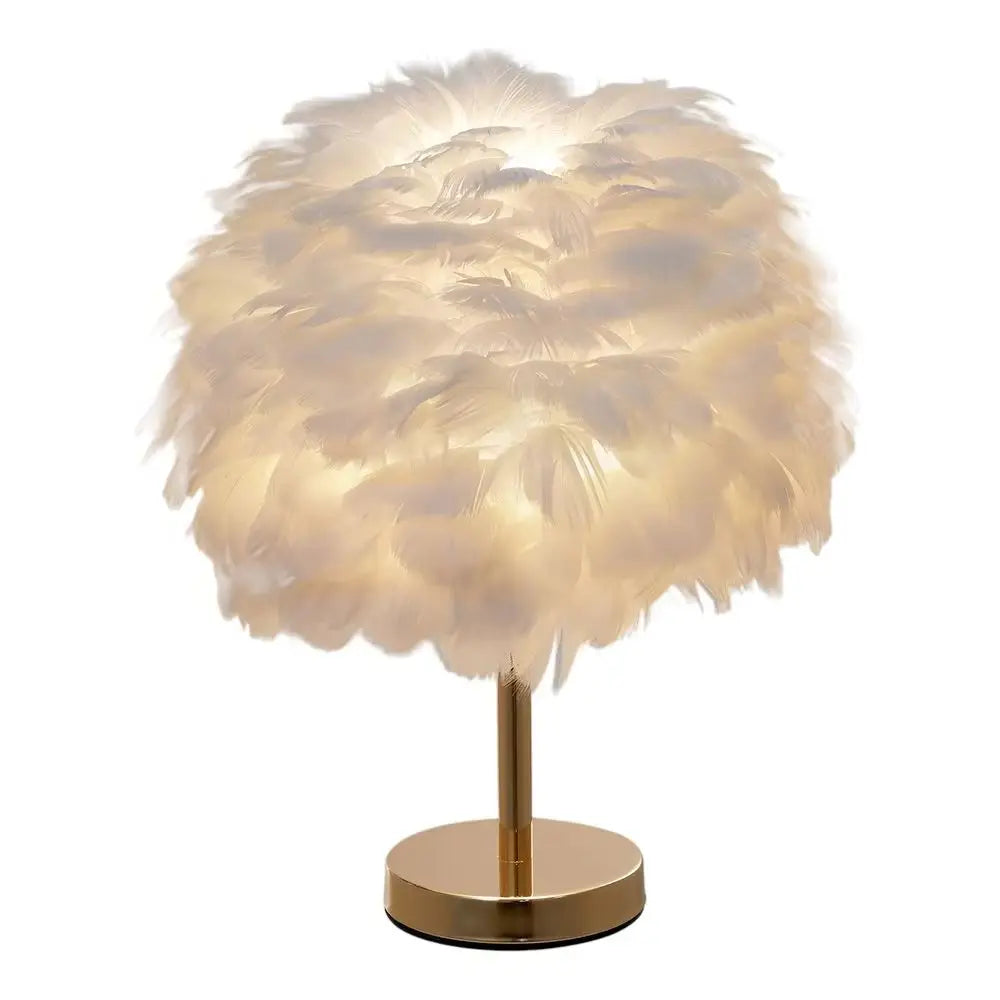 Feathered table lamp with gold base on a white background