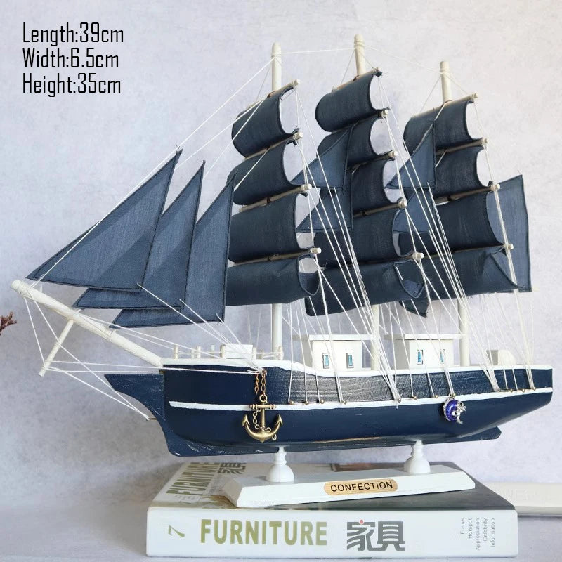 Model ship with blue sails on a white surface