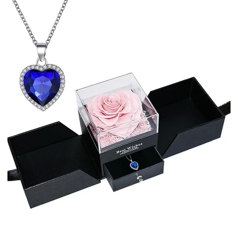Heart-shaped jewelry box with a preserved rose and necklace inside.