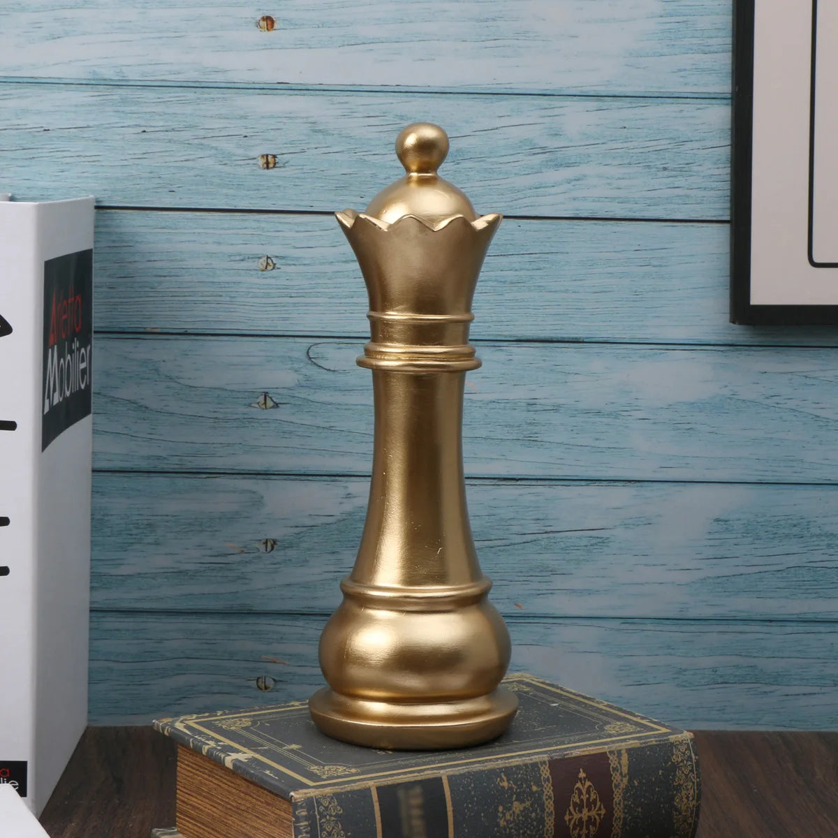 Gold chess piece on a stack of books with a blue wooden background