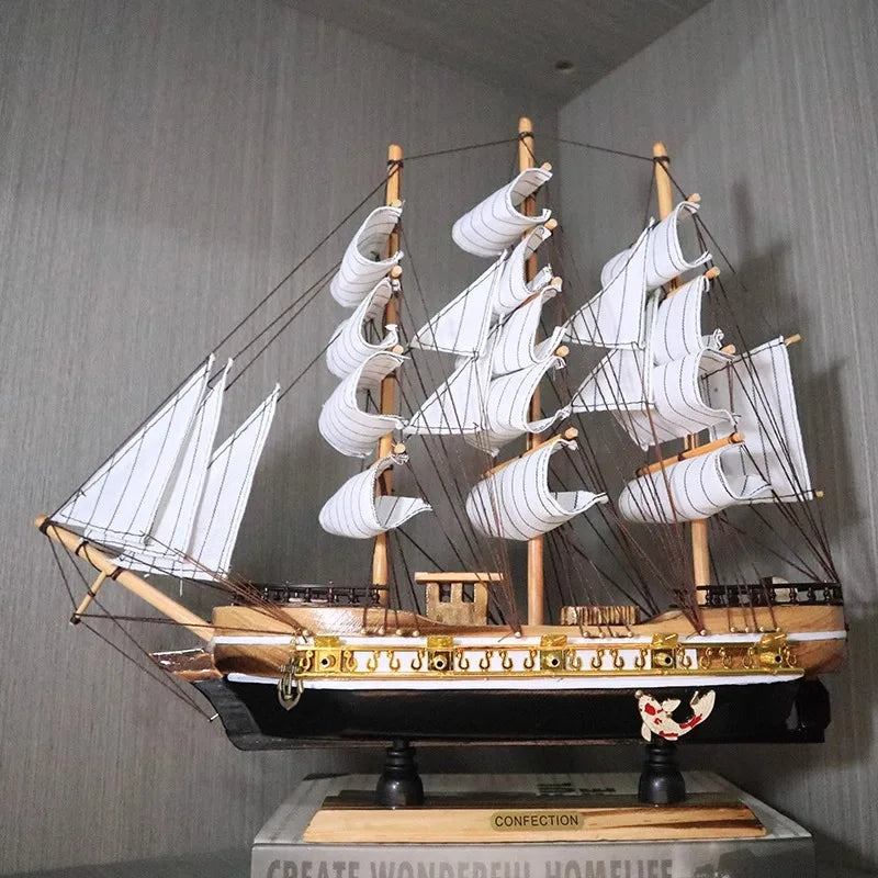 Model ship with white sails on a gray background