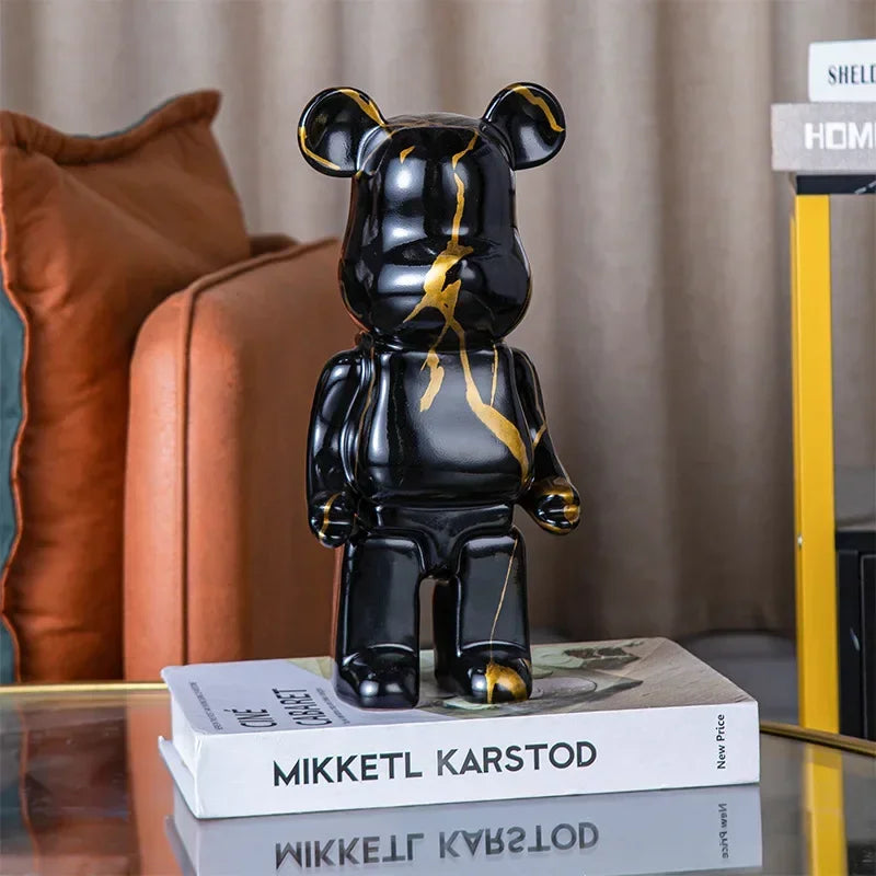 Black and gold bear figurine on a stack of books with a blurred background