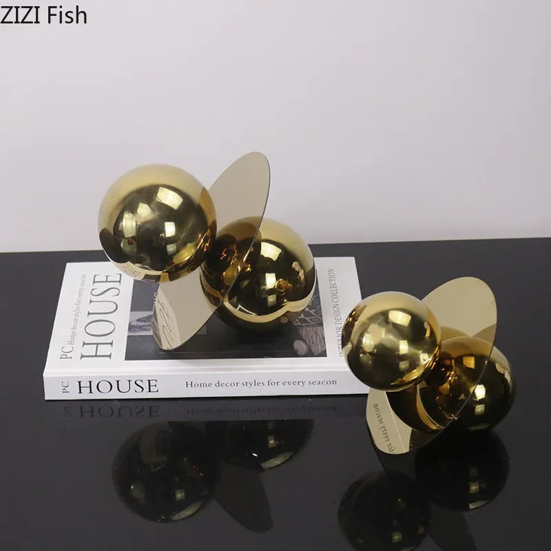 Two gold decorative propellers on a black surface with a book titled &