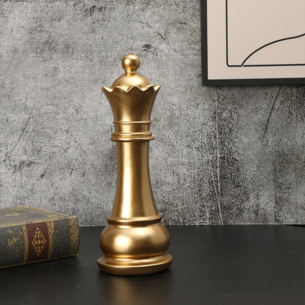 Gold chess piece on a dark surface with a textured gray wall in the background