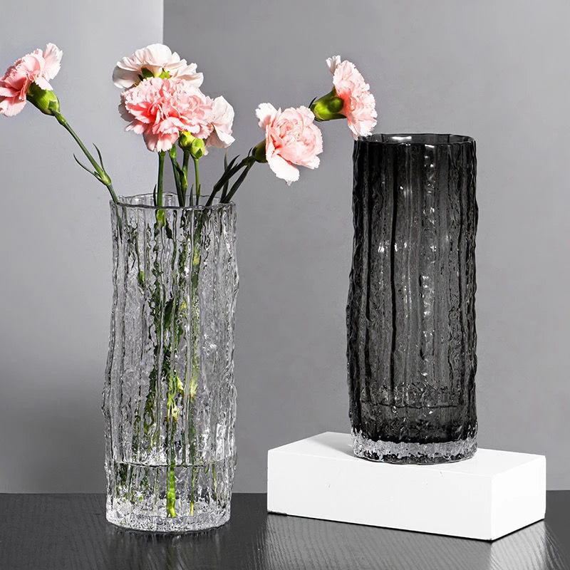 Two textured vases with pink flowers on a gray background