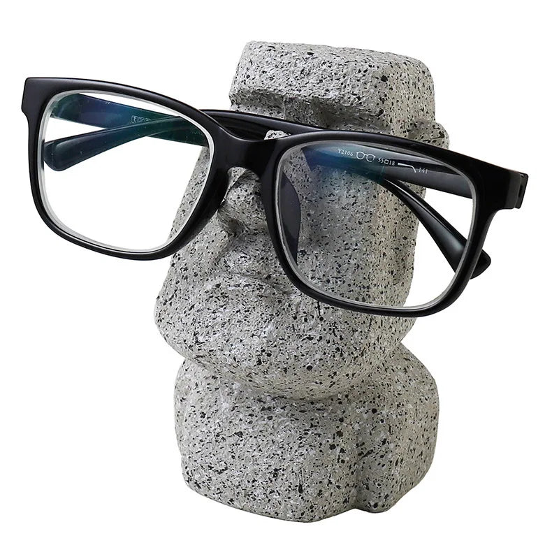 "Whimsical resin glasses holder on a living room shelf"