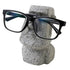 "Whimsical resin glasses holder on a living room shelf"