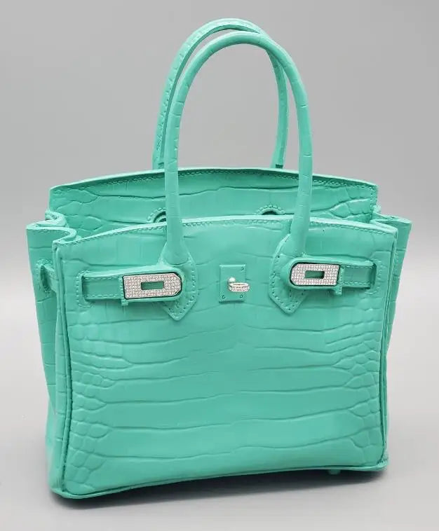 Turquoise handbag with diamond-studded clasp on a light grey background Resin vase for pampas grass