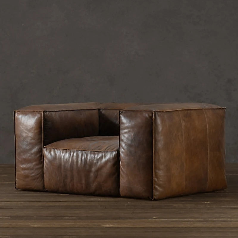 Brown leather dog bed on a wooden floor with a dark gray wall background