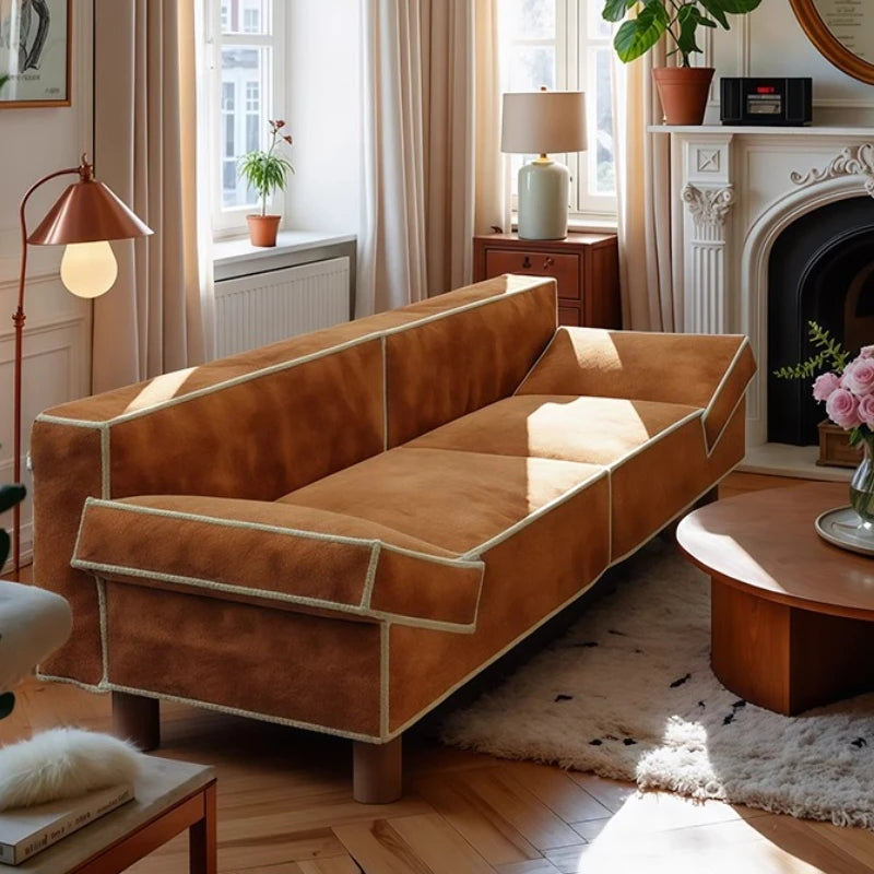 Brown sofa in a living room with wooden coffee table and decorative items.
