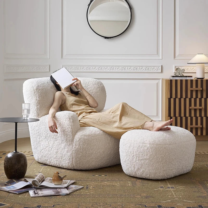 Person relaxing on a textured armchair with a footstool in a stylish room.