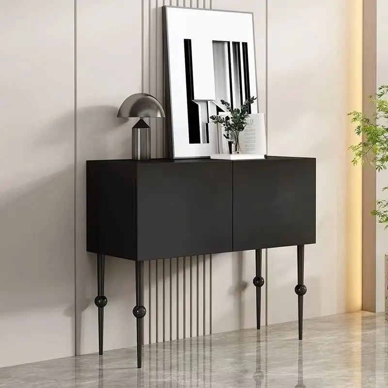 Modern black sideboard with decorative items in a minimalistic room.
