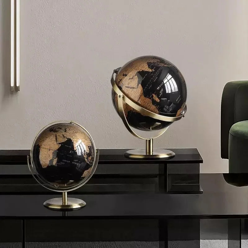 Two decorative globes on a dark surface with a neutral background