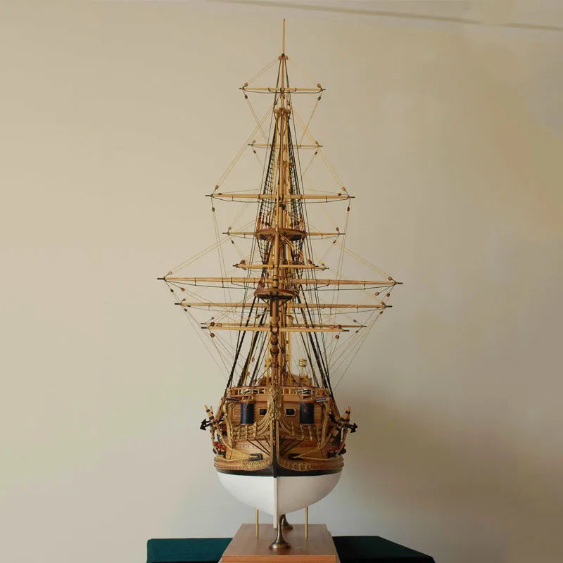 Model of a tall ship on a stand against a plain wall