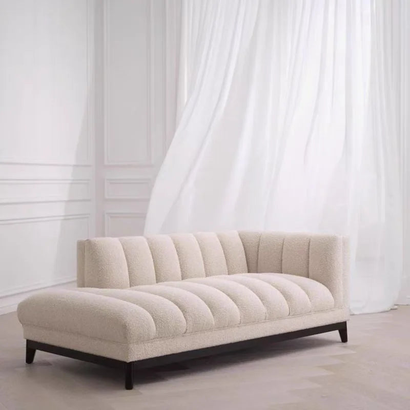 Beige sofa with black legs in a room with white walls and curtains