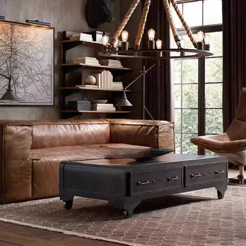 Brown leather sectional sofa in a living room with a bookshelf and large window.