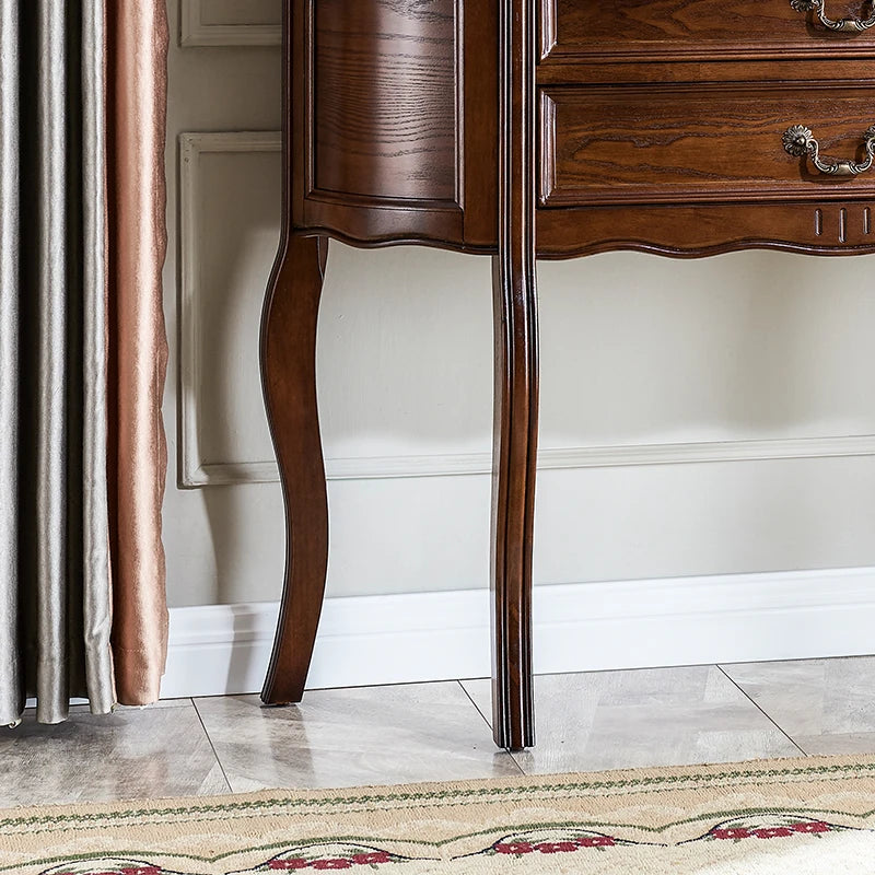 Wooden sideboard with elegant legs against a neutral wall.