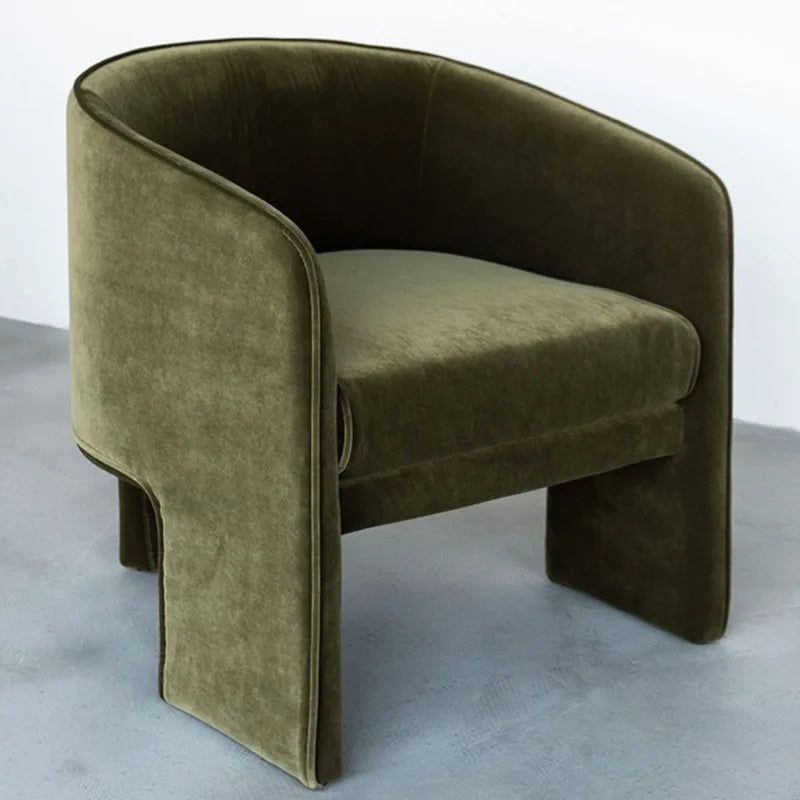 Green velvet armchair on a gray background